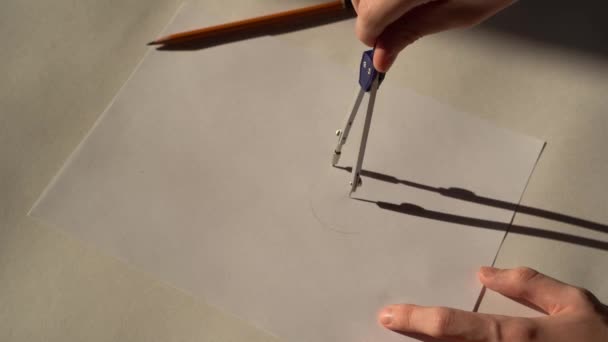 職場デザイナー 10代の若者の手は白い紙の上に晴れた日に描きます Circinus コンパス — ストック動画