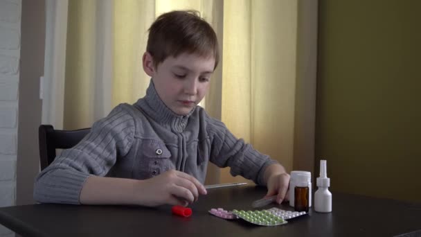 Joven Mirando Termómetro Una Mesa Oscura Hay Pastillas Cajas Blancas — Vídeo de stock