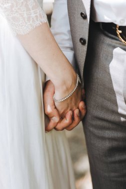 Gelin ve damadın elleri birbirine dokunur. Nazikçe dokunur, sarılır. Düğün, kutlama, tören