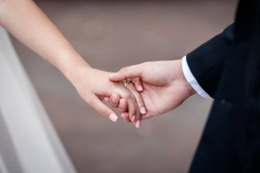 Gelin ve damadın elleri birbirine dokunur. Nazikçe dokunur, sarılır. Düğün, kutlama, tören