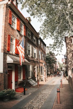 Eski cadde, kırmızı tuğla binalar. Evlerde bayraklar. Perspektif.