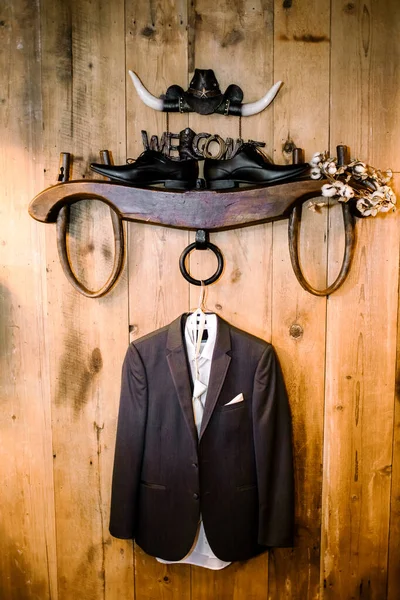 A man's suit for a wedding,celebration,or ceremony hangs on a hanger in the interior. Without man