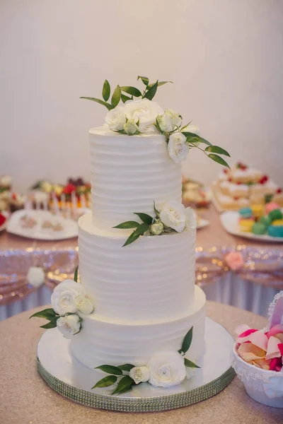 婚礼蛋糕 三层白色的 装饰着白花 在餐馆的桌子上 — 图库照片