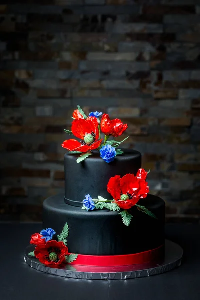 漂亮的双层黑蛋糕 用罂粟和玉米花装饰 红花和蓝花 非常有效的装饰 手工制作 — 图库照片