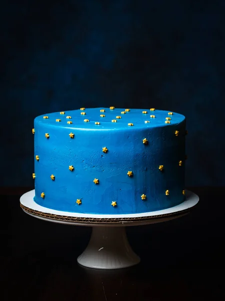 美丽的蓝色蛋糕 饰有星光 装饰夜色滑雪板 手工制作 白色瓷质高立柱 免版税图库照片