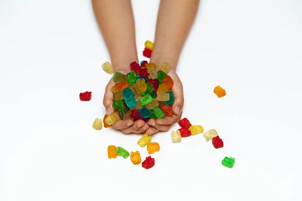 Beyaz arka planda kadın elleri ayı şeklinde marmelat tutar.