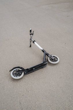 Şehirdeki asfaltta iki tekerlekli scooter var.