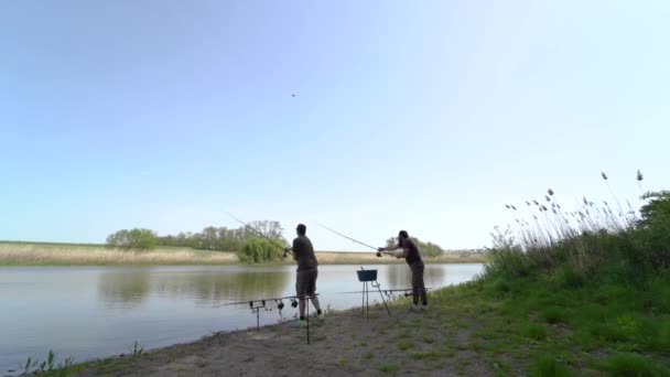 Két Halász Parton Két Fonórúddal Horgászik Örülnek Hogy Harapnak Berendezés — Stock videók