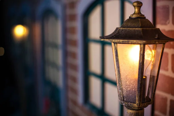 Уличная Лампа Светится Возле Кирпичного Дома — стоковое фото