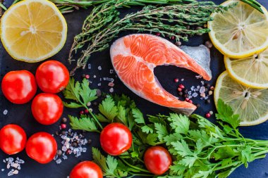 Siyah tahtada yeşil limonlu ve kiraz domatesli somon bifteği.