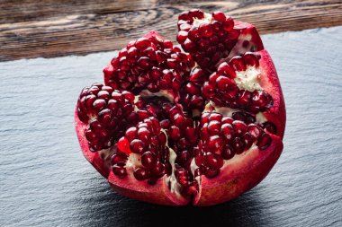 Siyah ahşap masada soyulmuş nar.