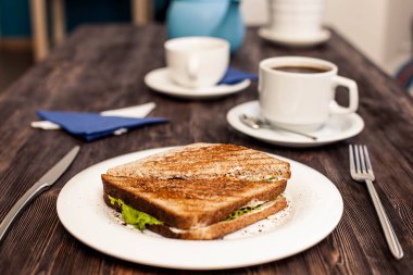 Lezzetli sandviç ve bir fincan kahve.