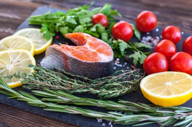 Siyah tahtada yeşil limonlu ve kiraz domatesli somon bifteği.