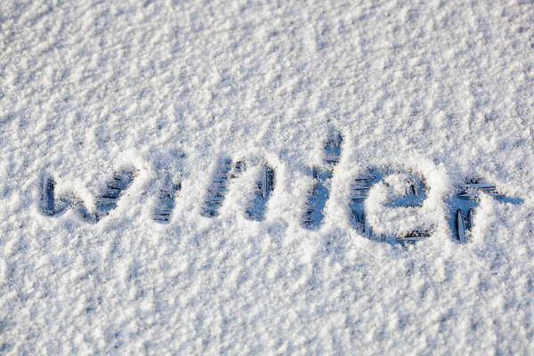 a word 'winter' written on the snow surface	