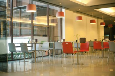 İçi turuncu mobilyalarla dolu boş bir kafe.