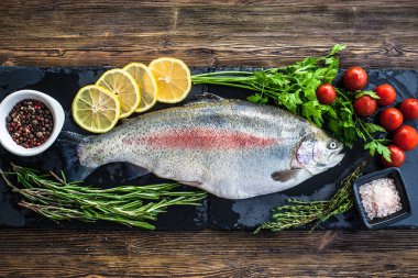 Büyük taze somon ve kara tahtada yeşillik.