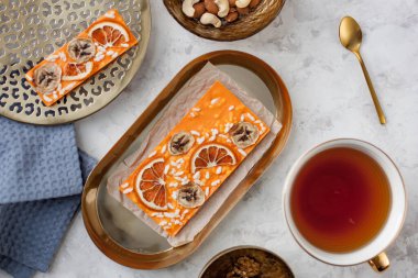 Portakallı, muzlu ve kabarık pirinçli portakallı çikolata bir fincan çayın yanında duruyordu.