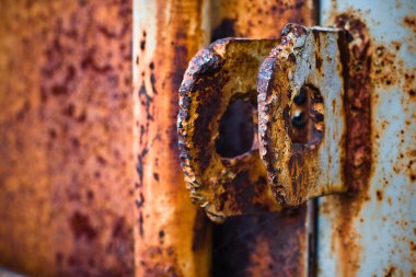 Paslı metal bir kapının üzerinde paslı bir bijon.