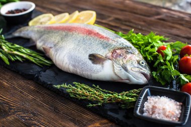 Büyük taze somon ve kara tahtada yeşillik.