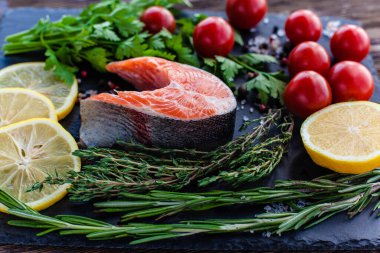 Bir taze somon bifteği, yeşil, limonlu ve vişneli domatesli.