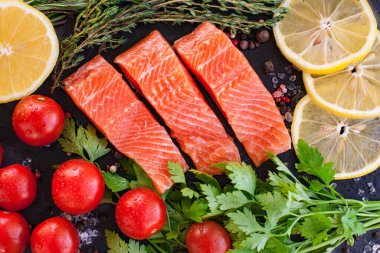 Kara tahtada yeşil limon ve kiraz domatesli üç somon bifteği.