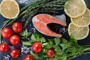 Bir taze somon bifteği, yeşil, limonlu ve vişneli domatesli.