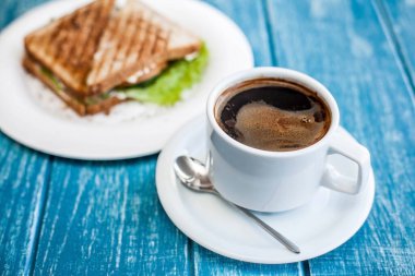 Bir fincan kahve ve iki kızarmış sandviçle kahvaltı.