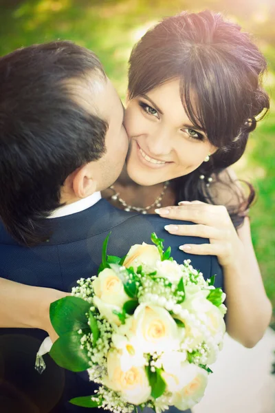 Gelin ve damat sarılıp öpüşüyor.