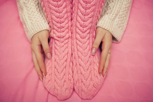 Bir çift yün çorap ve ellerle örülmüş kadın ayaklarına