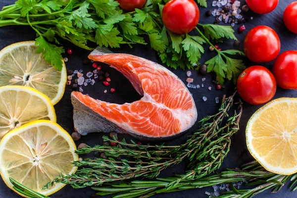 Siyah tahtada yeşil limonlu ve kiraz domatesli somon bifteği.