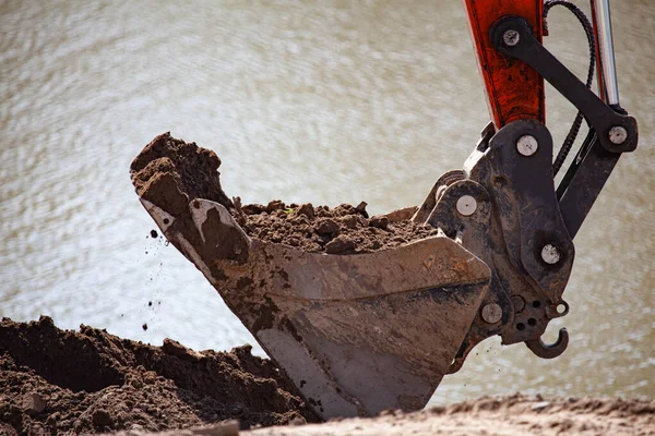 Kazı küreği toprağı kazıyor.