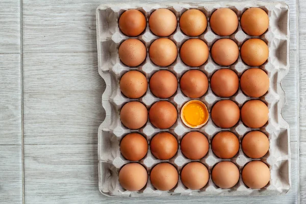 Ovos de galinha castanhos inteiros e um ovo partido — Fotografia de Stock