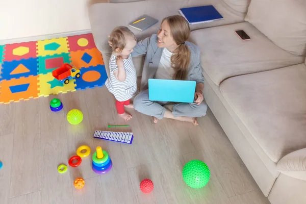 Çocuğuyla evde çalışan meşgul bir genç anne. Serbest, annelik, tecrit