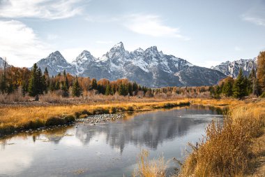 Wyoming 'deki Grand Teton Ulusal Parkı' ndaki Schwabacher 's Landing' deki Yılan Nehri 'ndeki Teton dağ sırası yansıması. Sonbahar manzarası, yeşil ağaçlar ve dağ suyu yansıması.. 