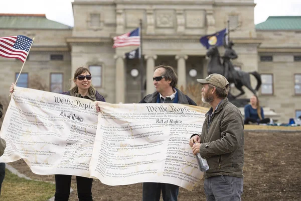 Helena, Montana - 19 Nisan 2020: Coronavirus 'un kapatılmasını protesto eden bir erkek ve kadın protestocu, Meclis binasının önünde İnsan Hakları Beyannamesi' nin pankartlarını tutuyor..