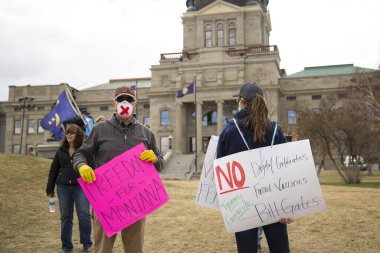 Helena, Montana - 19 Nisan 2020: Meclis 'te maskeli, eldivenli ve özgürlük ve aşılara karşı pankartlı protestocular, Bill Gates ve Covid-19' un kapatılması üzerine zorbalığa karşı göstericiler.