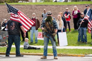 Helena, Montana - 20 Mayıs 2020: Silahlı bir adam, milis üyesi, Meclis binasında, bir grup protestocunun önünde yarı otomatik bir silahla protesto yapıyor..
