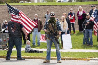 Helena, Montana - 20 Mayıs 2020: Silahlı bir adam, milis üyesi, Meclis binasında, bir grup protestocunun önünde yarı otomatik bir silahla protesto yapıyor..