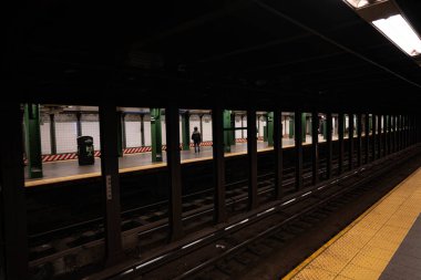 New York City, New York / ABD - 28 Mart 2020: Boş New York Şehri metroları ve terli maskeler ve koruyucu eldivenlerle metroya binen insanlar