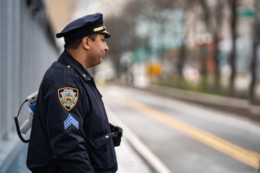 New York Şehri, New York / ABD - Nisan 12020: Polis, salgın Corona virüsü salgını sırasında NYC sokaklarını koruyan sağlık görevlisi.