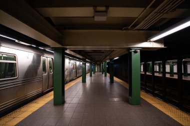 New York City, New York / ABD - 28 Mart 2020: Boş New York Şehri metroları ve terli maskeler ve koruyucu eldivenlerle metroya binen insanlar