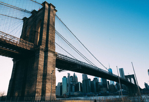New York City, New York / USA - May 19 2020: Brooklyn Bridge. Historic landmark of New York. Bridge reflection after rain. Iron cables of Brooklyn Bridge