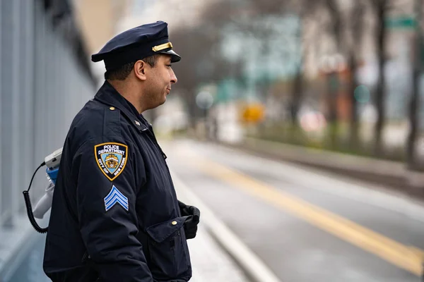 New York Şehri, New York / ABD - Nisan 12020: Polis, salgın Corona virüsü salgını sırasında NYC sokaklarını koruyan sağlık görevlisi.