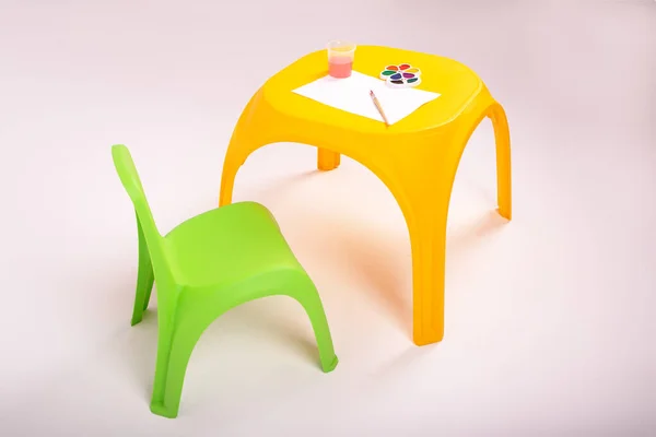 Mesa de plástico amarelo das crianças e cadeira verde no fundo branco — Fotografia de Stock