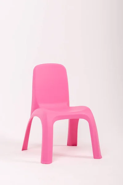 ピンクのプラスチックの子供たちが白い背景で椅子を — ストック写真