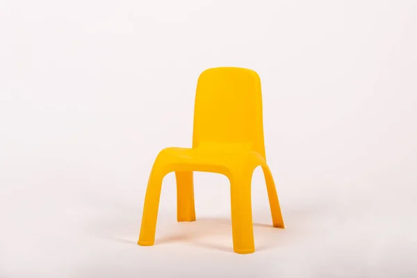 Жовтий пластиковий дитячий стілець на білому фоні — стокове фото