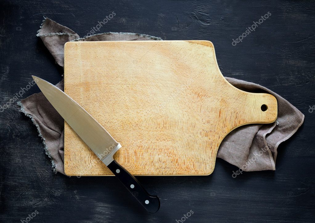Cooking concept, dark moody rustic kitchen background with an empty cutting board and Knife on it, space for a text, view from above