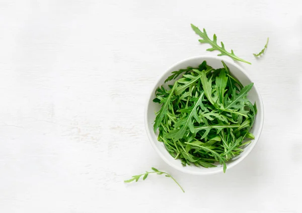 Arugula folhas em uma tigela branca — Fotografia de Stock