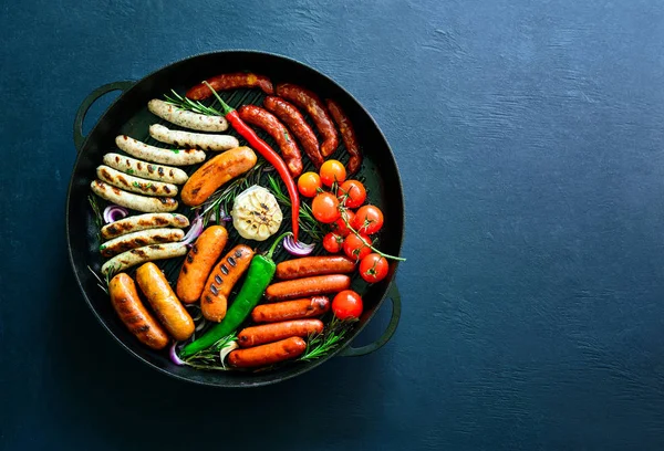 Разнообразные жареные сосиски на сковороде — стоковое фото