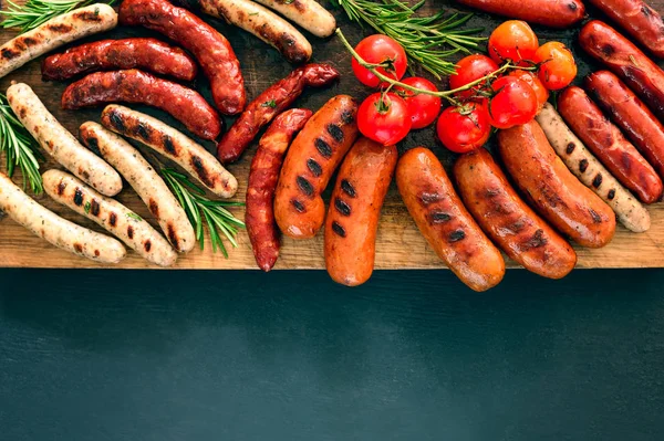 Embutidos a la parrilla en una tabla — Foto de Stock